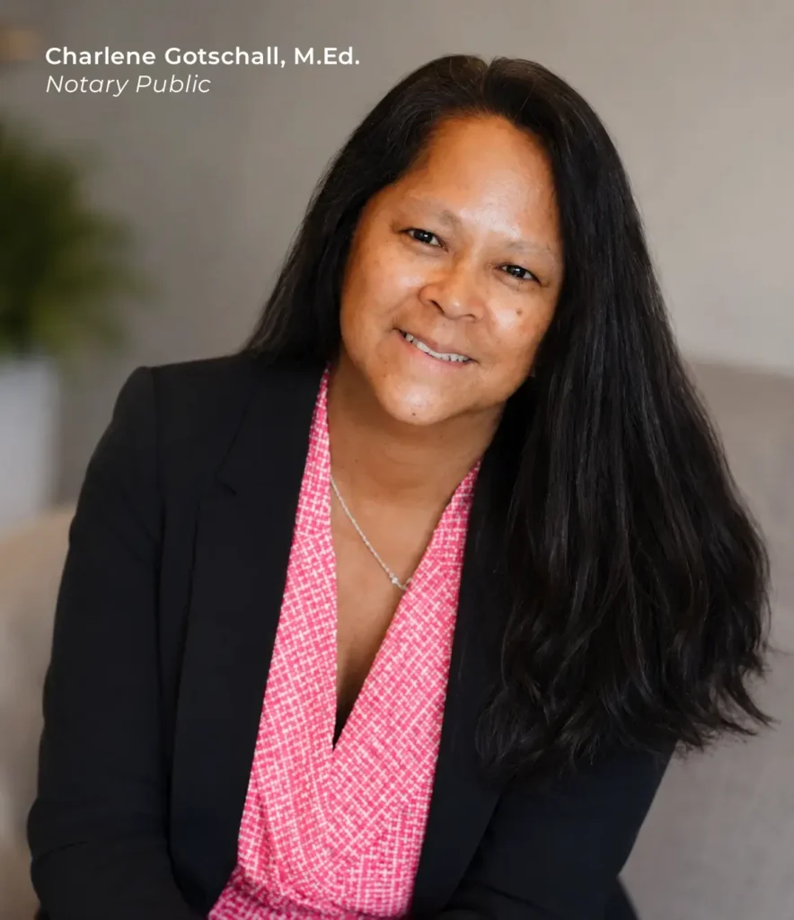 Black-haired notary Charlene Gotschall headshot, head angled to the right, wearing a black blazer and a pink blouse.